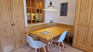 a dining room with a wooden table and chairs at Chesa Bellaval, Haus Leivra 2 1 2-Zimmerwohnung in Silvaplana