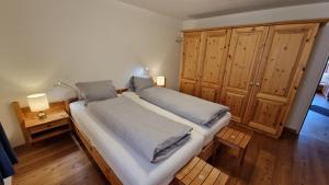 a large bed in a room with wooden cabinets at Chesa Bellaval, Haus Leivra 2 1 2-Zimmerwohnung in Silvaplana