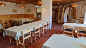 una fila de mesas y sillas en un restaurante en Chesa Bellaval, Haus la Vuolp 2 1 2 Zimmerwohnung en Silvaplana