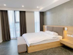 a bedroom with a large bed with white sheets at TSQ STAY Hotel Apartment in Hanoi