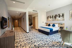 a hotel room with a bed and a living room at Grand Kingsgate Jaddaf Waterfront Hotel by Millennium in Dubai