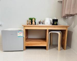 a table and a small refrigerator in a room at Muji Hotel KrabI in Krabi