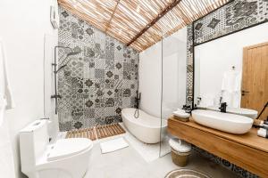 een badkamer met een bad, een toilet en een wastafel bij Hijau Villa by EVDEkimi Ubud in Ubud