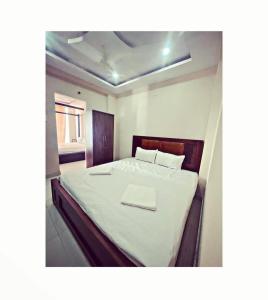 a bedroom with a large bed with a white blanket at Reef Hotel in Shamshabad