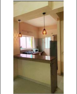 una cocina con dos luces colgando sobre un mostrador en Reef Hotel en Shamshabad