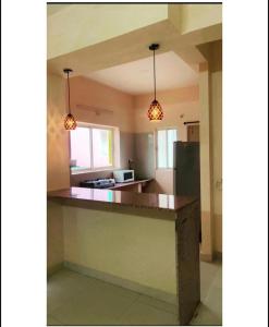 a kitchen with two lights hanging over a counter at Reef Hotel in Shamshabad