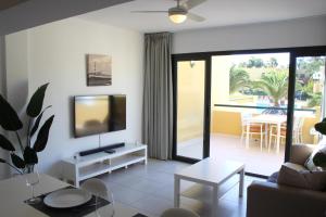 Una sala de estar con un sofá y un televisor. en Pachi Beach Atlantic Garden Corralejo, en Corralejo