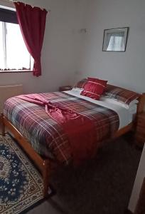 a bedroom with a bed with red pillows and a window at The Retreat in Pett