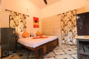 a bedroom with a bed and a television in it at Ocean View Cottage in Calangute