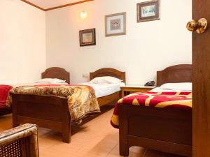 a hotel room with two beds in a room at Hotel Devika in Dibrugarh