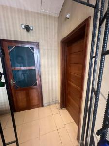 a room with a wooden door and a tiled floor at Luxury 2 Bedroom family Apartment in Yaba Lagos in Lagos