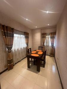 a dining room with a table and chairs and curtains at Luxury 2 Bedroom family Apartment in Yaba Lagos in Lagos