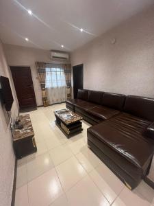 a living room with a leather couch and a coffee table at Luxury 2 Bedroom family Apartment in Yaba Lagos in Lagos