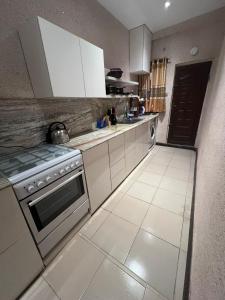 a kitchen with white cabinets and a stove at Luxury 2 Bedroom family Apartment in Yaba Lagos in Lagos