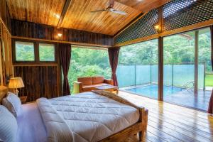um quarto com uma cama e uma piscina em The Arboreal Resort em Āmbavna
