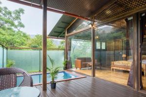 uma casa com uma piscina num deque de madeira em The Arboreal Resort em Āmbavna