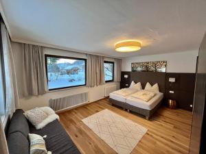 1 dormitorio con cama, sofá y TV en Pension Gruber en Weisspriach