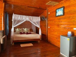 a bedroom with a bed in a wooden cabin at Kohjum Relax Beach in Ko Jum