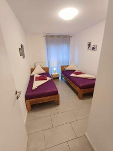two beds in a room with purple sheets at Apartment/Wohnung direkt in Aschaffenburg in Aschaffenburg
