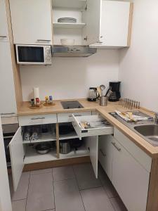 a small kitchen with white cabinets and a sink at Apartment/Wohnung direkt in Aschaffenburg in Aschaffenburg