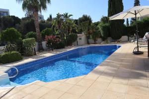 a swimming pool in a yard with an umbrella at Villa Prengos 7 in Neo Chorio