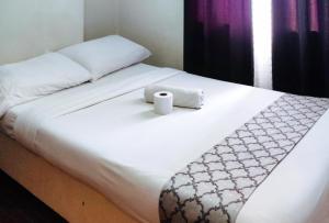 a bed with two towels on top of it at RedDoorz at Goldentown Hotel Davao City in Davao City