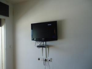 einen Flachbild-TV, der an einer Wand hängt in der Unterkunft Appartement CORNICHE vue sur MER in Martil