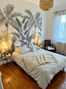 Saint-Julien-sur-CherにあるLa Briquetteのトロピカルな壁紙のベッドルーム1室(大型ベッド1台付)