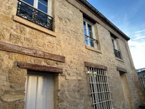 - un bâtiment en pierre avec une fenêtre et une porte dans l'établissement Appartement duplex à Chantilly centre, à Chantilly