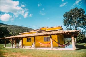 ein kleines gelbes Haus mit einem Dach in der Unterkunft Casa Flor da Serra in Nobres