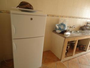 eine Küche mit einem weißen Kühlschrank und einer Spüle in der Unterkunft Appartement CORNICHE vue sur MER in Martil