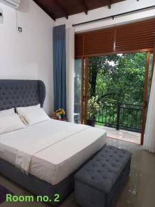 een slaapkamer met een bed en een groot raam bij Gampaha Heritage in Gampaha