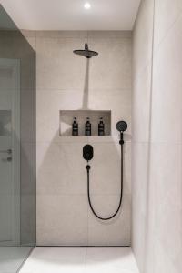 a bathroom with a shower with four bottles on a shelf at Altstadt-App. Domblick! in Salzburg