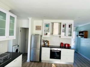 Cape Town的住宿－Unit 17 , 72 on Arnold street Two Bedroom Flat，厨房配有白色橱柜和不锈钢冰箱