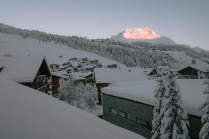 a snow covered town with a mountain in the background at Margarethe Apartments Lech in Lech am Arlberg