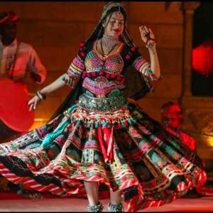 a woman in a colorful dress dancing on a stage at Jaisal heritage desert camp in Jaisalmer