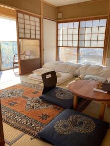 een woonkamer met een tafel en een tapijt bij 小舞庵 Komaian in Tokushima