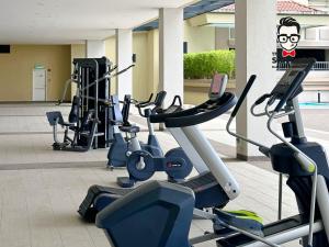 einem Fitnessraum mit mehreren Kardiogeräten in einem Gebäude in der Unterkunft Staycation Homestay 34 Kuching Riverine Petanak Resort in Kuching