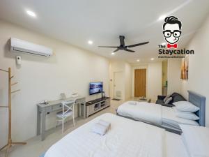 1 Schlafzimmer mit 2 Betten, einem Schreibtisch und einem Deckenventilator in der Unterkunft Staycation Homestay 34 Kuching Riverine Petanak Resort in Kuching