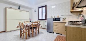 レッジョ・エミリアにあるGUEST HOLIDAY BETTOLAのキッチン(テーブル、椅子、冷蔵庫付)