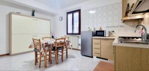 Una cocina con mesa y sillas y un refrigerador. en GUEST HOLIDAY BETTOLA, en Reggio Emilia 5 fotos más
