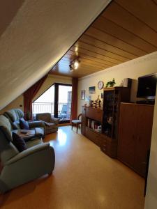 ein Wohnzimmer mit einem Sofa und einem TV in der Unterkunft Panorama Oase Ferienwohnung mit Blick auf Mosel und Reichsburg in Cochem