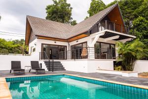 a villa with a swimming pool and a house at Coco Lilly Villas in Wok Tum