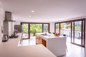 eine Küche mit weißen Arbeitsflächen und einem großen Fenster in der Unterkunft Coco Lilly Villas in Wok Tum