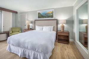een slaapkamer met een groot wit bed en een stoel bij OUTRIGGER Kaua'i Beach Resort & Spa in Lihue