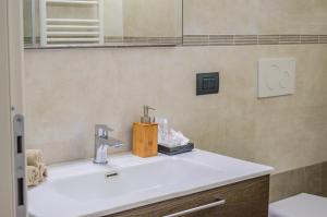een badkamer met een wastafel en een spiegel bij Esclusivo Loft Centro Storico private garden E-Bike in Cherasco