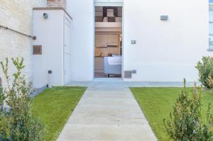 een wit huis met een deur naar een tuin bij Esclusivo Loft Centro Storico private garden E-Bike in Cherasco