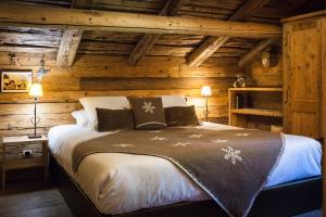 a bedroom with a large bed in a log cabin at Les Chalets PVG in La Clusaz