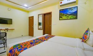 a bedroom with a large bed in a room at FabExpress Purple Suites Inn in Bangalore