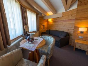 uma sala de estar com um sofá e uma mesa em Bio Hotel Brusago Vital & Wellness em Bedollo